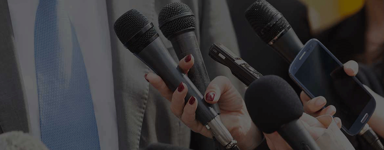 Microphones held in front of man in suit