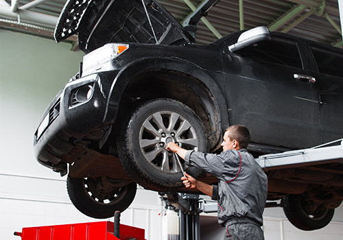 Mechanic under vehicle on lift