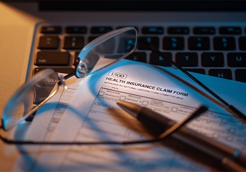 Medical-Providers-Thumbnail reading glasses and pen on paper health form