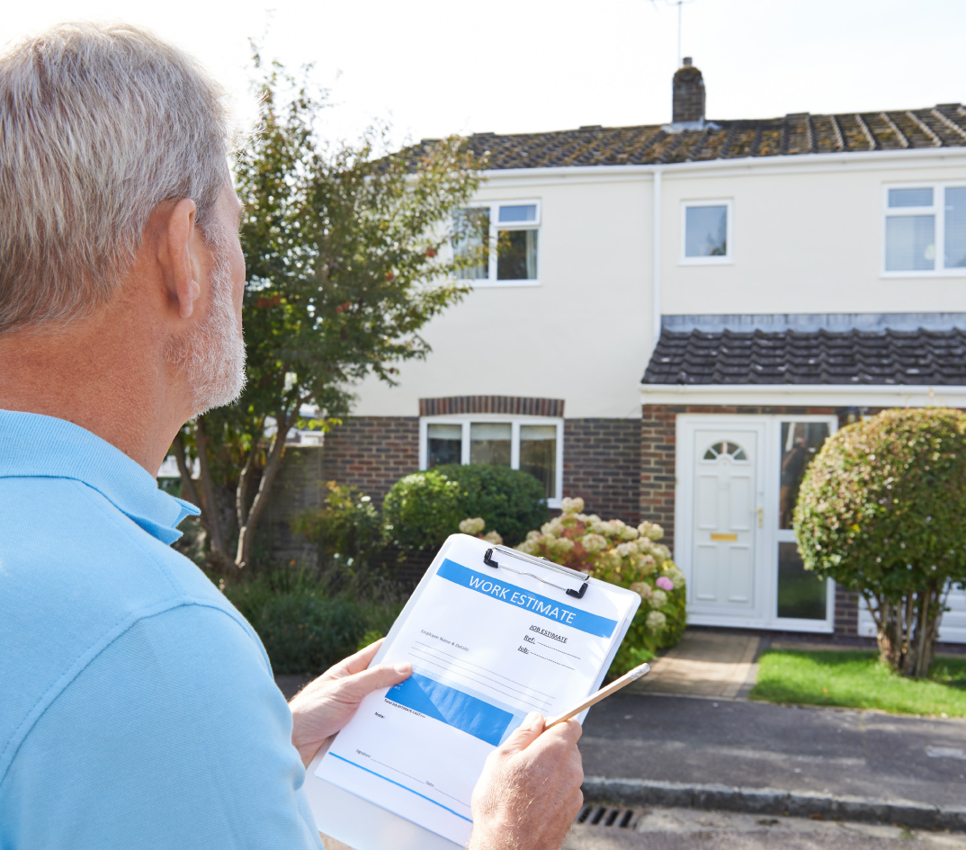 Man with clipboard inspecting home for work estimate