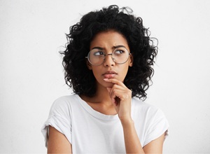 Woman Questioning Young woman in glasses with puzzled look on her face
