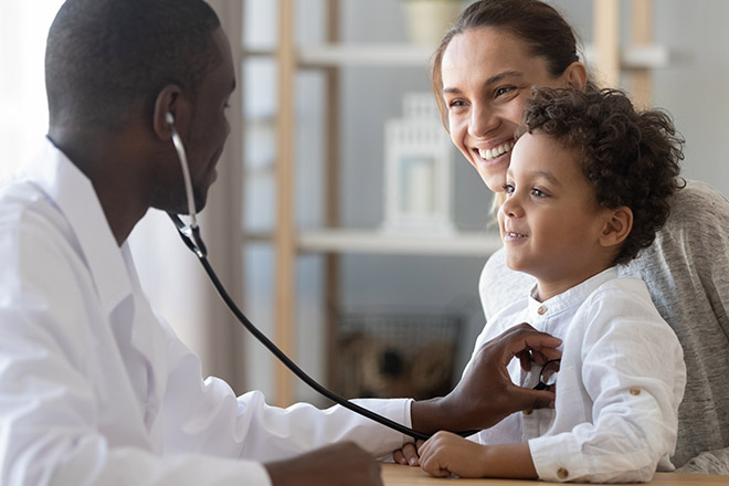Biracial Child and Caucasian Mother With Black Doctor at Exam