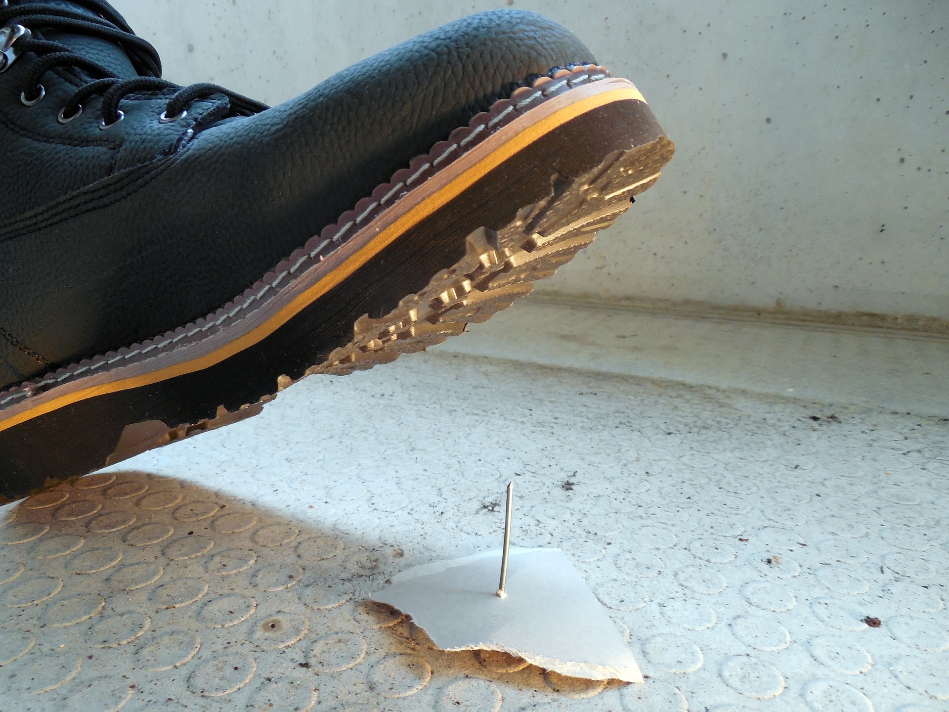 Work boot stepping on a nail