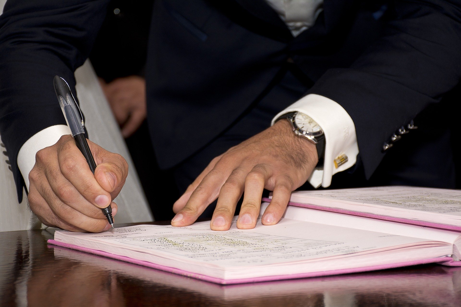 man signing documents